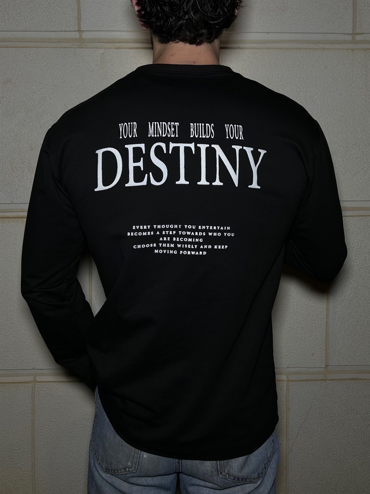 The back of the black Destiny long sleeve, YOUR MINDSET BUILDS YOUR DESTINY over four smaller lines