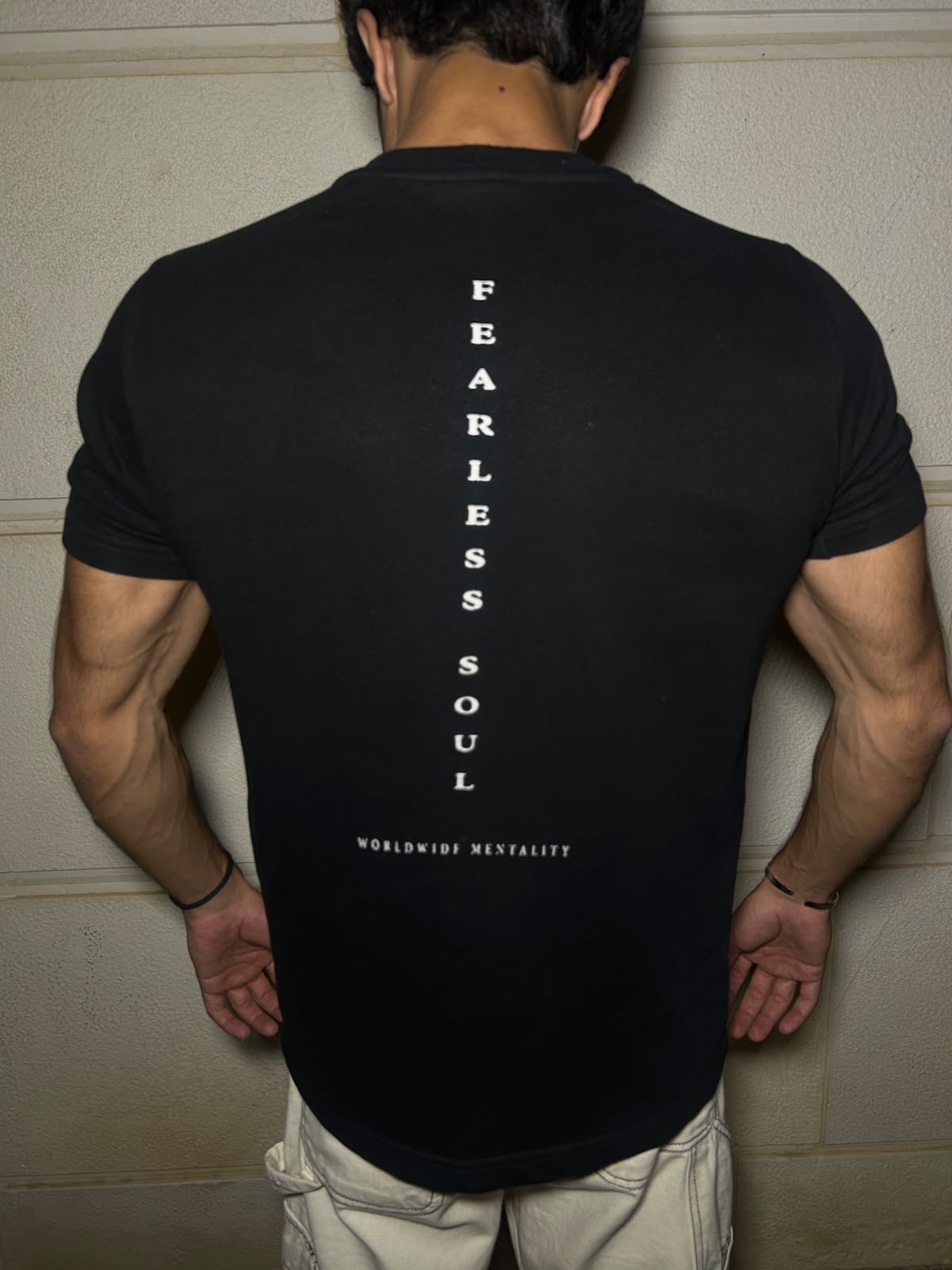 The back of the black Fearless Soul tee, FEARLESS SOUL set vertical down the spine over WORLDWIDE MENTALITY
