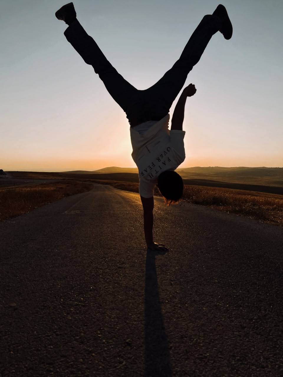 Handstand on an empty road at sunset