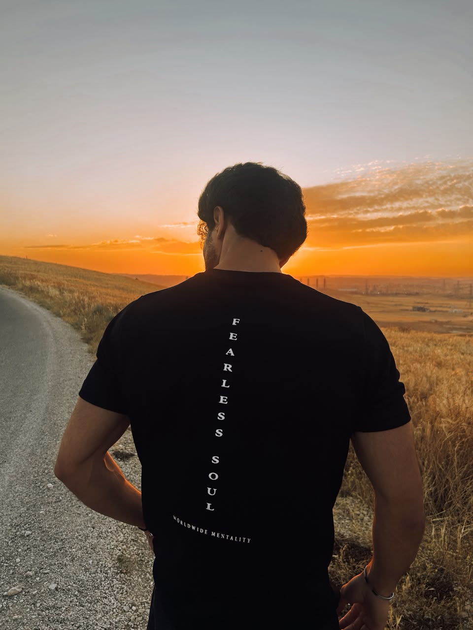 Back of the black Fearless Soul tee on a road at sunset