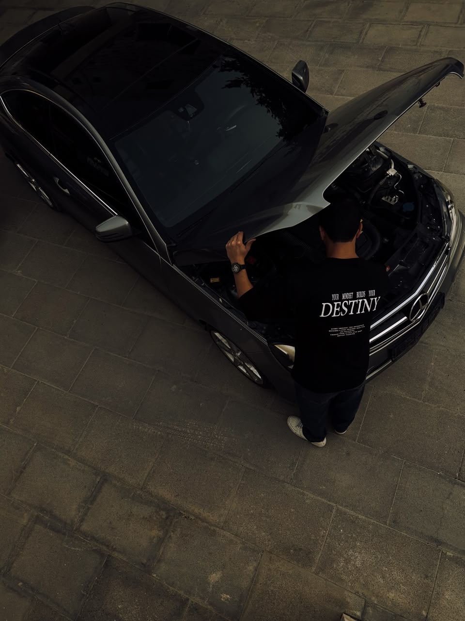 Overhead, the Destiny tee beside a car