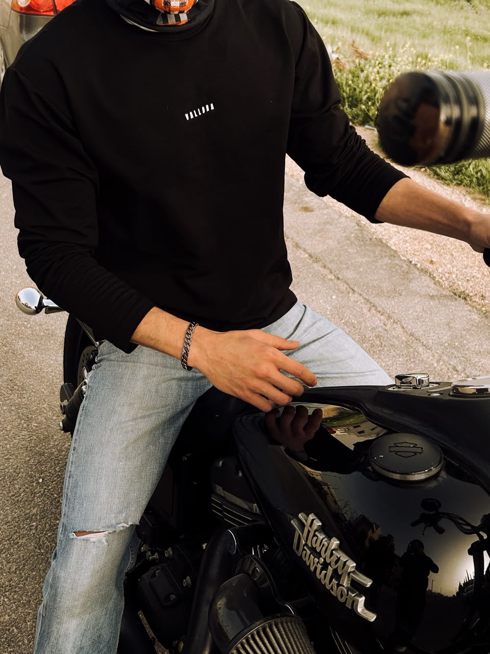 The long sleeve with the chest mark, sitting on a motorcycle